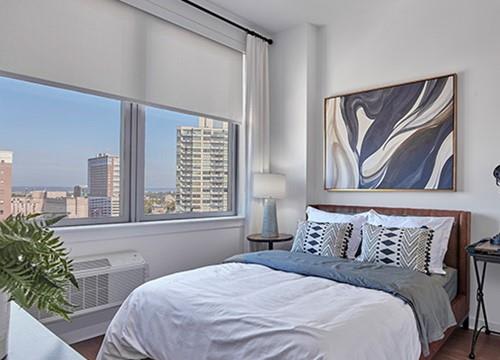 a bedroom with a bed and a large window
