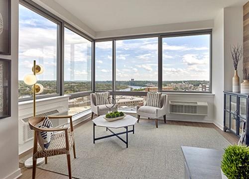 a living room with a view of a city and a table and chairs