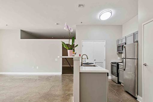 A kitchen with a refrigerator, microwave, and oven.
