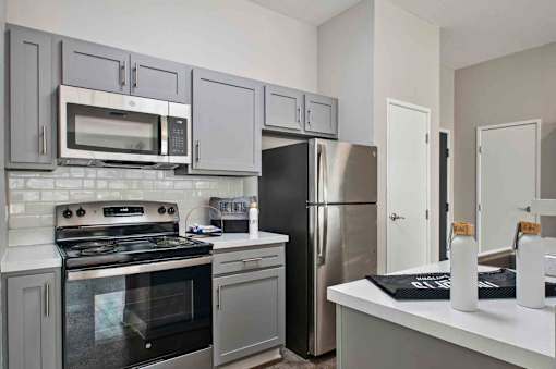 A kitchen with a stove, oven, refrigerator, and microwave.