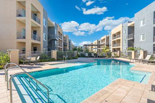 A swimming pool in front of apartment buildings.
