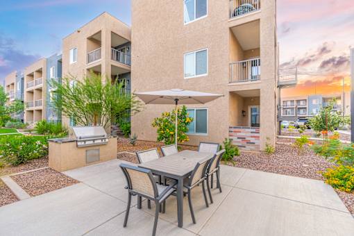 A patio with a table and chairs is in front of a building.