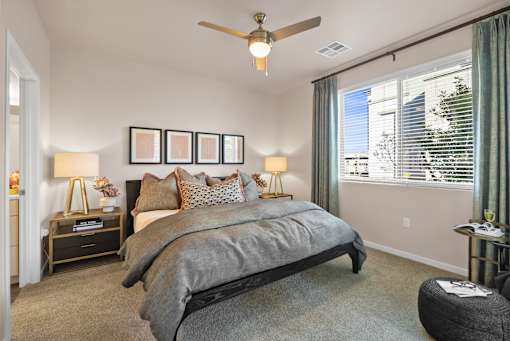 A bedroom with a large bed and a ceiling fan.