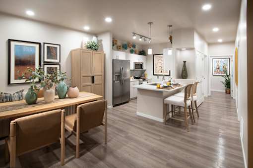 A modern kitchen with wooden chairs and a dining table.