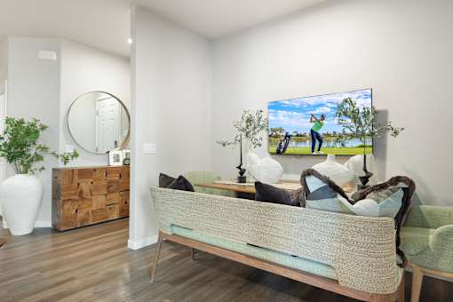 A bedroom with a bed, a mirror, a painting, and a plant.