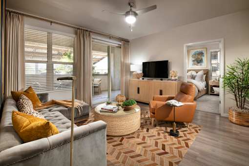 A living room with a grey couch, a brown armchair, a coffee table, and a television.