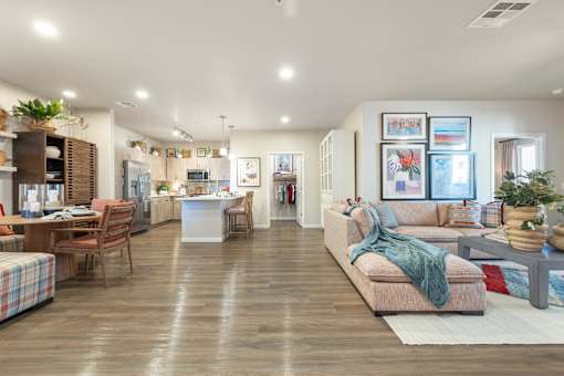 A spacious living room with a couch, chairs, and a dining table.