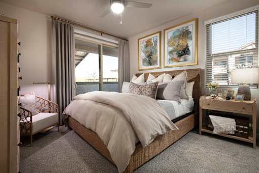 A bedroom with a large bed and a ceiling fan.