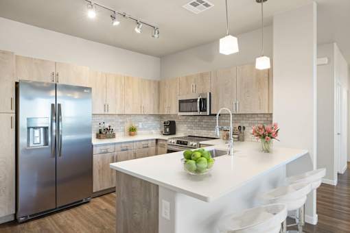 A modern kitchen with a large island and stainless steel appliances.