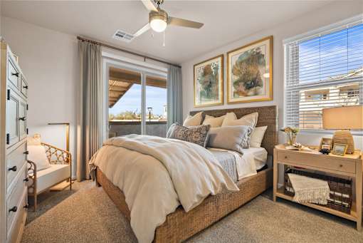 A bedroom with a large bed and a ceiling fan.