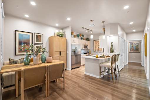 A kitchen with a dining table and chairs.