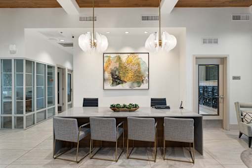 A dining room with a large table and chairs.