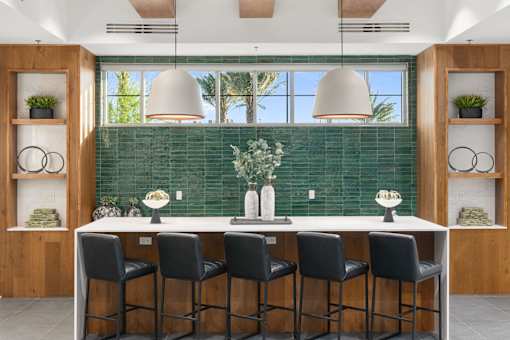 A kitchen with a green backsplash and a white countertop.