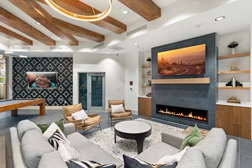 A modern living room with a fireplace and a painting on the wall.