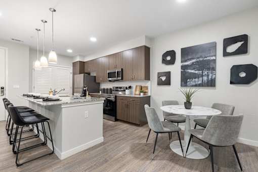 A modern kitchen with a dining table and chairs.