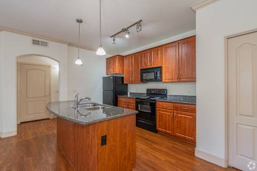 A kitchen with wooden cabinets and a granite countertop.