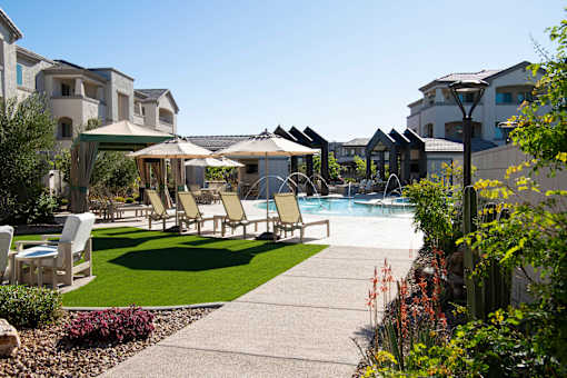 A poolside area with chairs and umbrellas.
