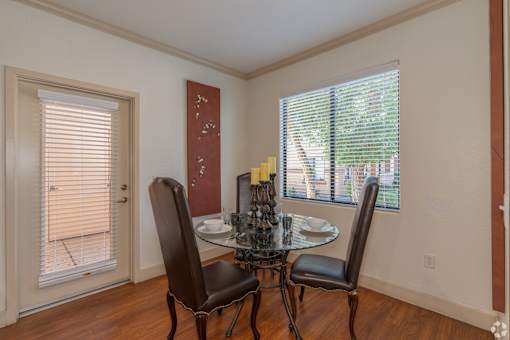 A dining room with a table and chairs.