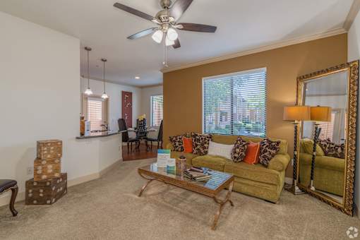 A living room with a yellow couch and a wooden coffee table.