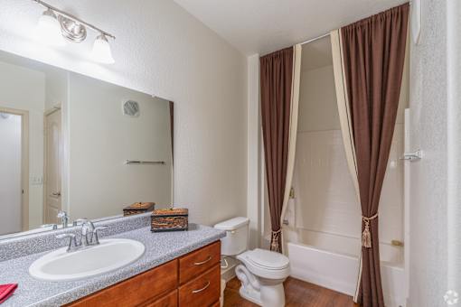 A bathroom with brown curtains and a white toilet.
