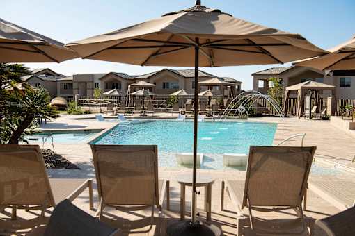 A poolside scene with chairs and umbrellas.