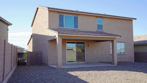 A house with a gravel driveway and a fence.