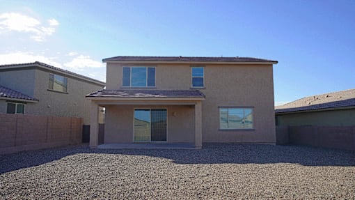 A house with a gravel driveway in front.