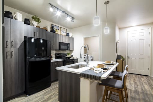 a kitchen with a large island and black appliances