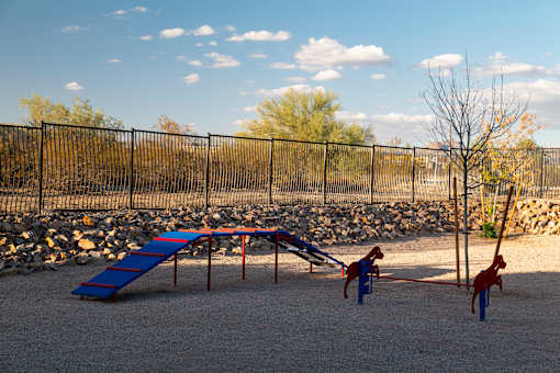 A playground with a blue slide and red climbing frame.