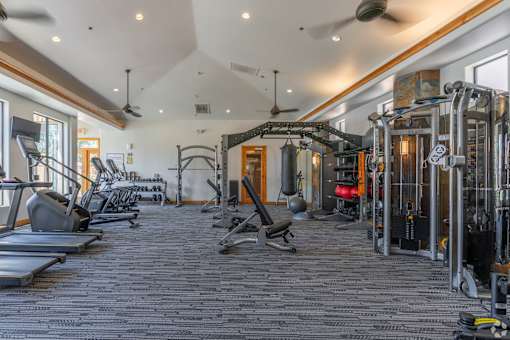 A spacious gym with a variety of equipment including treadmills, weights, and exercise machines.