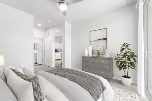 a bedroom with a large bed and a dresser with a plant on it