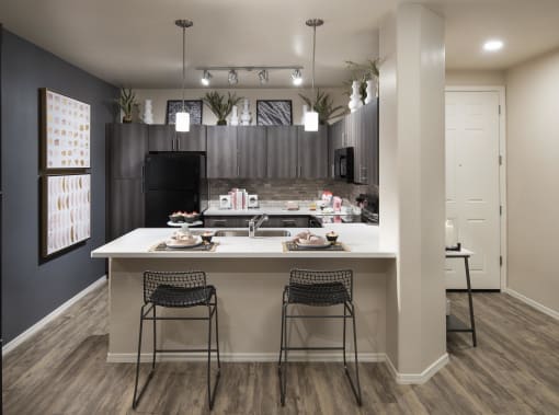 an open kitchen with a large island with two stools