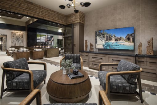 a lobby with chairs and a table and a tv