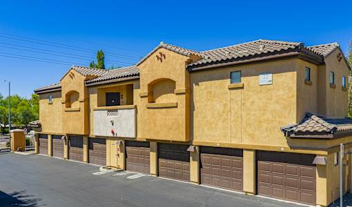 A row of tan stucco houses with garage doors.