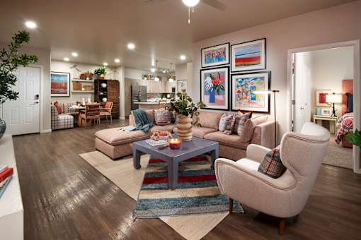 A living room with a couch, chair, and a table with a candle on it.