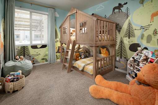 A child's room with a wooden bunk bed and a large teddy bear.
