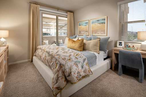 A bedroom with a large bed and a window with curtains.