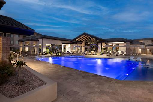 A large outdoor swimming pool with a blue light reflection at the bottom.
