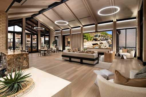 A modern living room with a large sofa and a TV on the wall.