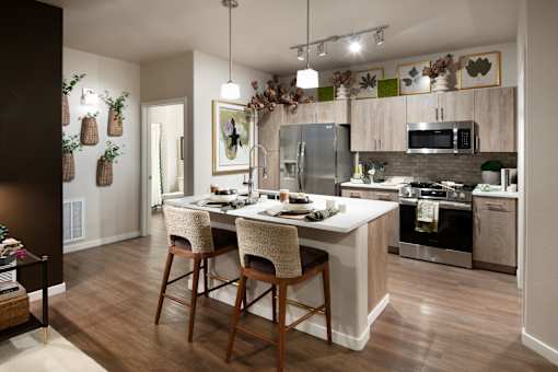 A kitchen with a table and chairs in front of a refrigerator.