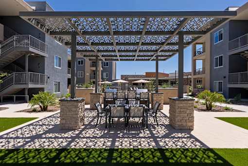 A patio with a table and chairs is surrounded by apartment buildings.