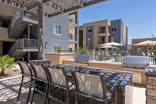 A patio with chairs and a table is in front of a building.