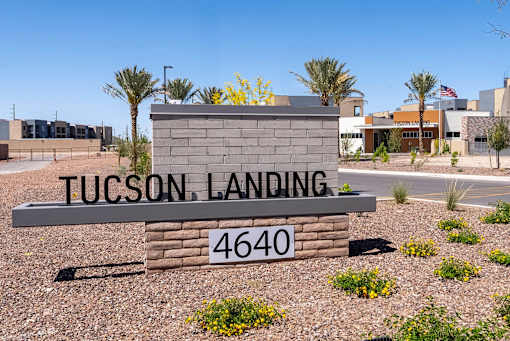A sign that says Tucson Landing 4640 in front of some buildings.
