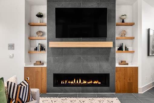 A modern living room with a fireplace and a flat screen TV mounted above it.