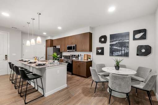 A modern kitchen with a dining table and chairs.