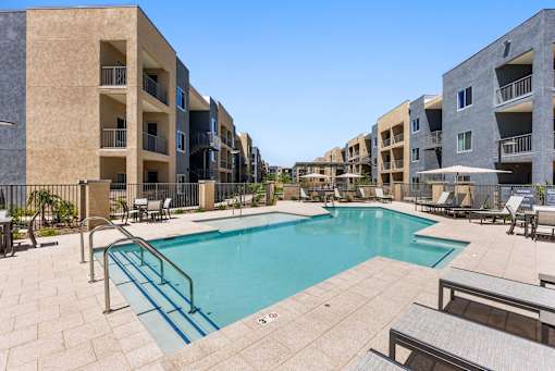 A swimming pool surrounded by apartment buildings.
