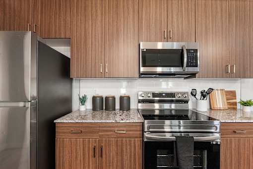 A modern kitchen with wooden cabinets and stainless steel appliances.