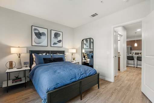 A bedroom with a large bed and a mirror on the wall.