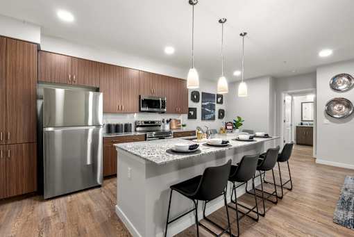 A modern kitchen with a large island and stainless steel appliances.