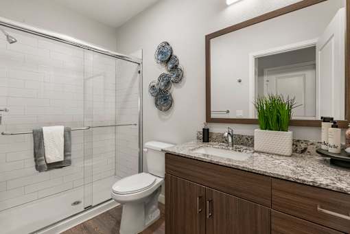 A bathroom with a toilet, sink, and shower.